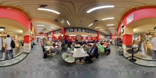 a group of people sitting at tables in a mall at Happy Stay in Mestre