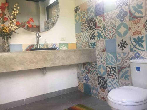 La salle de bains est pourvue de toilettes, d'un lavabo et d'un miroir. dans l'établissement Finca Australia, à Quebradanegra