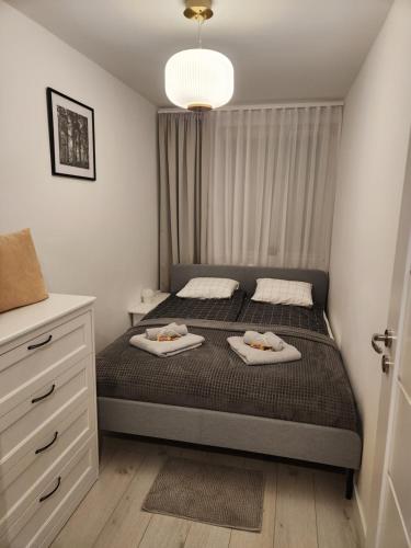 ein Schlafzimmer mit einem Bett mit zwei Handtüchern darauf in der Unterkunft Moon Apartment in Breslau