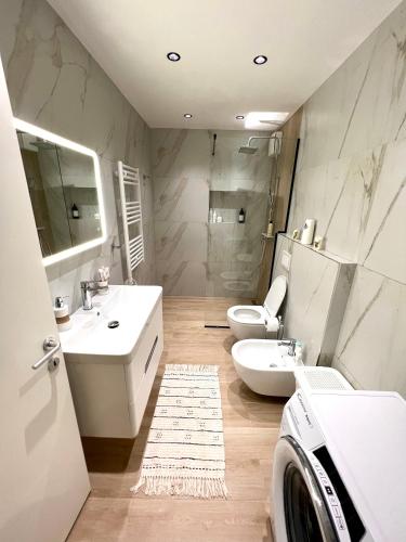 a white bathroom with two sinks and a toilet at Center of Tirana - Apartment in Tirana