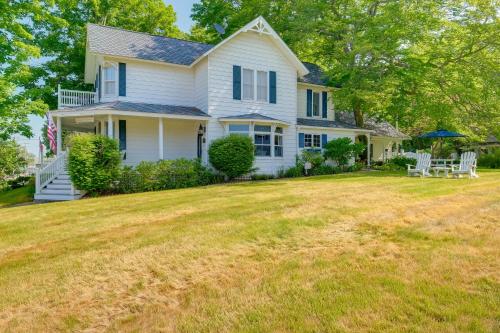 a white house with a large yard at Elegant 1905 Home Steps to Torch Lake and Dtwn in Alden