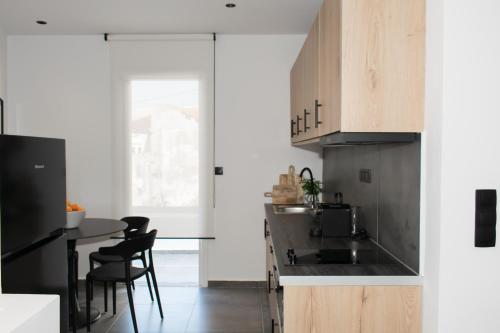 a kitchen with wooden cabinets and a table and chairs at Gioia I & Gioia II in Rethymno