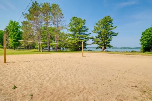 an empty volleyball court with a net in the sand at Elegant 1905 Home Steps to Torch Lake and Dtwn in Alden