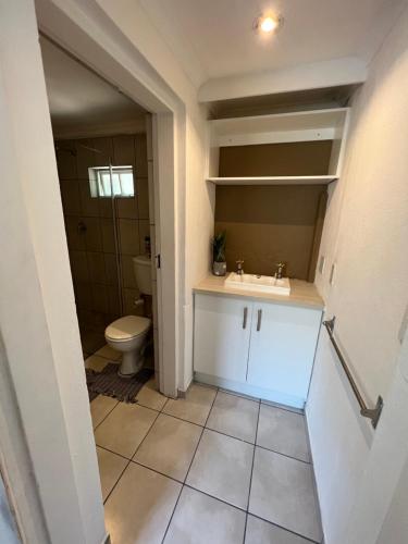 uma casa de banho com um lavatório e um WC em Stunning stay in Sandton - back up power & view em Joanesburgo