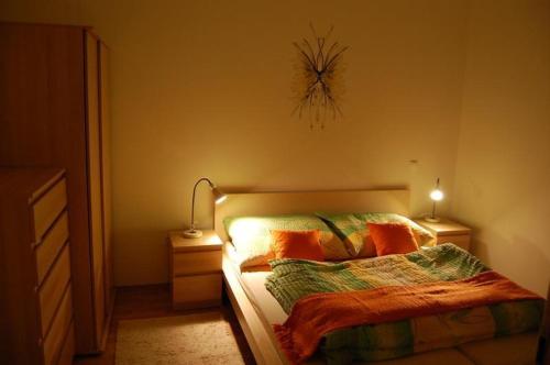 1 dormitorio con 1 cama con almohadas de color naranja y lámpara en Nová Ponorka Martinské Hole Martinky en Martinske Hole