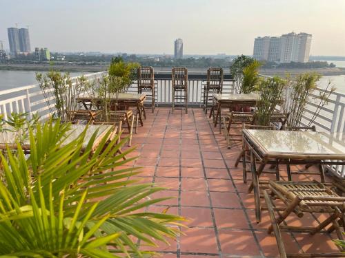 a patio with tables and chairs next to the water at 4 RIVERS HOTEL in Phnom Penh