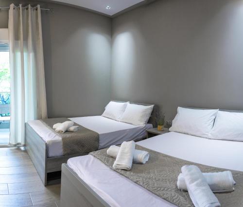 1 dormitorio con 2 camas y toallas. en NikoleTakis Apartments en Paralia Panteleimonos