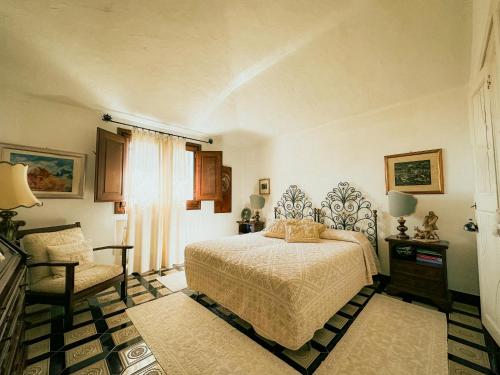 Sardinian Luxury Hospitality - Villa Fuli Rooms and more في غولفو أرانتْشي: غرفة نوم بسرير وكرسي