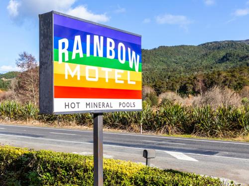 a rainbow motel sign on the side of a road at Rainbow Motel & Hot Pools in Turangi