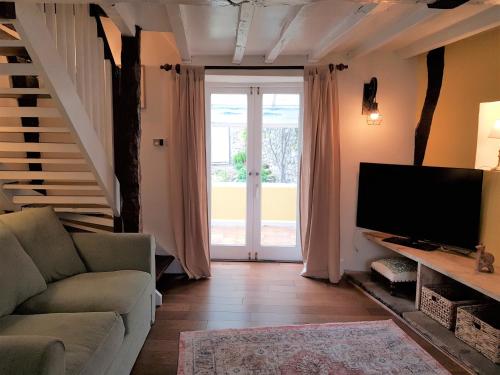a living room with a couch and a flat screen tv at Cruck Cottage - Gorgeous 300 Year Old Cottage Mins from North Yorkshire Moors, Steam Trains and Picturesque Pickering in Pickering