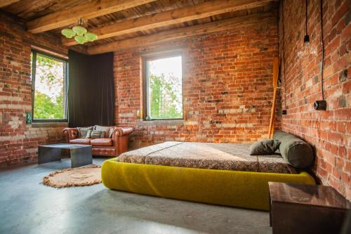 a bedroom with a large bed in a brick wall at Agroturystyka Gorzelnia Gwieździn in Gwieździn