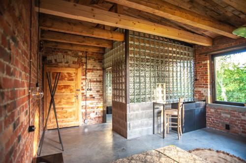a room with a brick wall and a kitchen with a counter at Agroturystyka Gorzelnia Gwieździn in Gwieździn