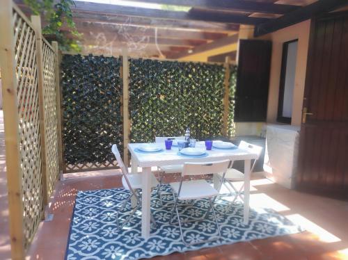 a white table and chairs on a patio at holiday house "Lo Stuggio" Pinus Village chia in Fort Village