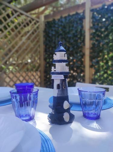 a lighthouse figurine sitting on a table with two cups at holiday house "Lo Stuggio" Pinus Village chia in Fort Village