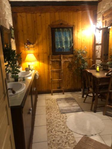 a bathroom with a sink and a table in it at Chambre d'hôte txaleta (le Chalet) in Saint-Priest-sous-Aixe