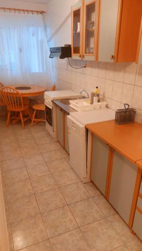 a kitchen with a sink and a stove and a table at Apartments Duce (122) in Duće