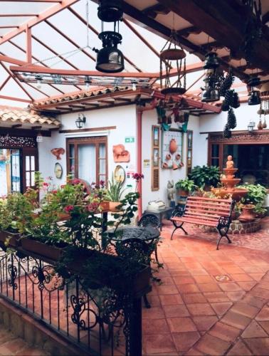 a patio with a bench and a building at Hotel Villa Cristina in Villa de Leyva