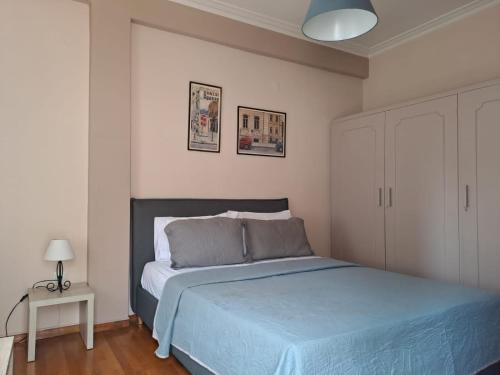 a bedroom with a bed with a blue comforter at Central Museum Comfort Appartment in Athens