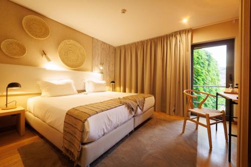 a hotel room with a bed and a window at Hotel Folgosa Douro in Armamar