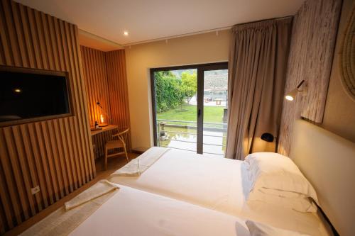 a bedroom with a large bed and a window at Hotel Folgosa Douro in Armamar