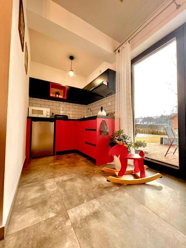 a living room with a red kitchen and a table at Domek pod Tatrami Jurgów noclegi in Jurgów