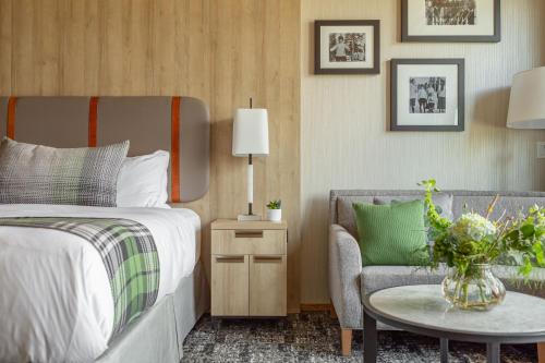 una camera con letto, sedia e tavolo di Headwaters Lodge at Eagle Ranch Resort a Invermere