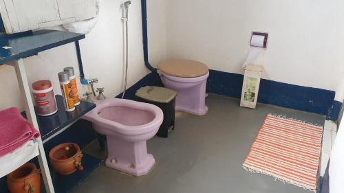 y baño con aseo rosa y bidet. en Casa do Barão, São José das Três Ilhas, en Belmiro Braga