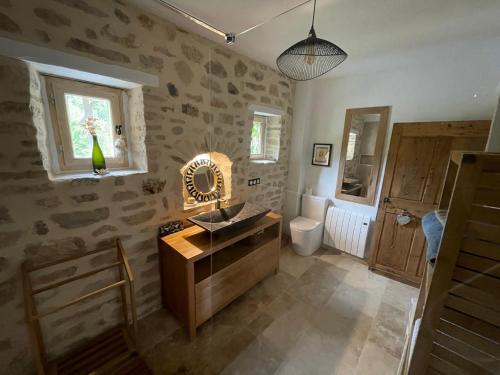 Saint-André-de-RoquepertuisにあるMas du Bassacのバスルーム(洗面台、トイレ、鏡付)