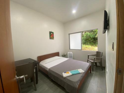 a small bedroom with a bed and a window at Amazonas magic in Leticia