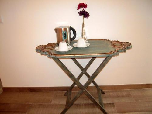 a table with a coffee cup and flowers on it at Monte do Cardal in Odeceixe