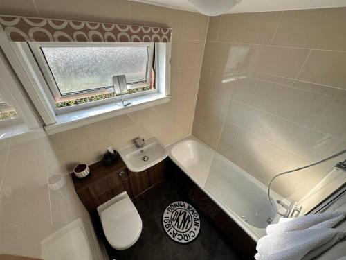 a bathroom with a sink and a toilet and a window at The Red Door, Two-Bedrooms Apartment in Edinburgh