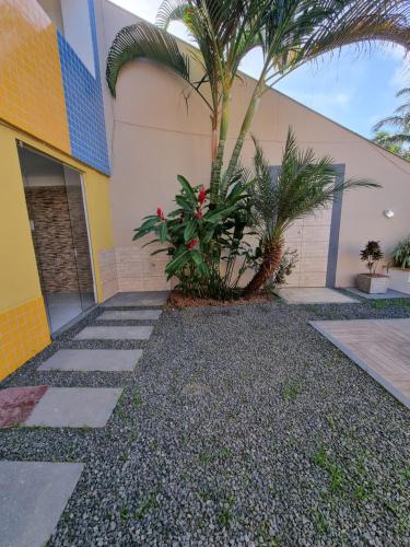 a house with a palm tree next to a building at Residência Wimbledon in Ilhéus
