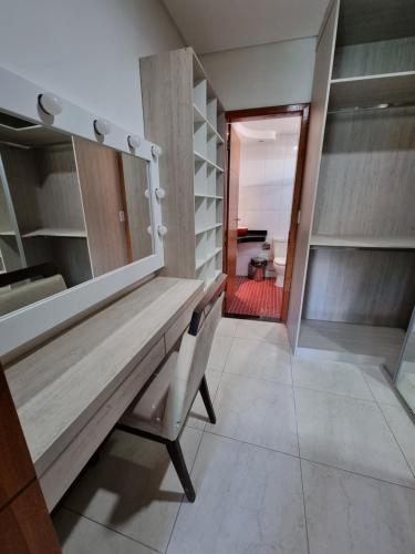 a wooden table and a chair in a room at Residência Wimbledon in Ilhéus
