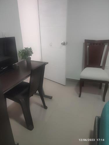 a desk with a computer and a chair in a room at Habitación en casa ambiente familiar in Cartagena de Indias