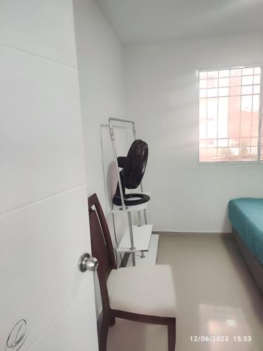 a room with a chair and a bed and a window at Habitación en casa ambiente familiar in Cartagena de Indias