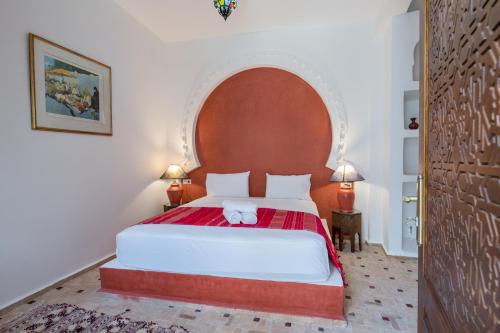 a bedroom with a large bed with an arch overhead at Riad SULTANA in Tangier