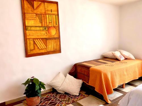 a room with a bed and a painting on the wall at Casa Don Pancho in Cuernavaca