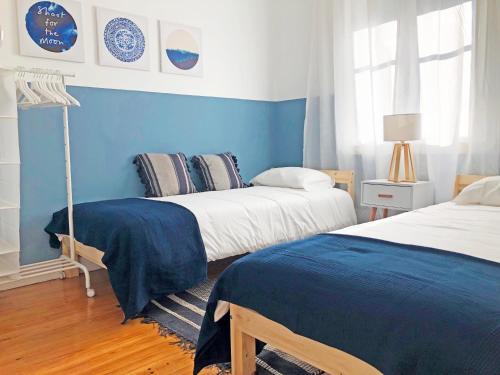 ein Schlafzimmer mit zwei Betten und einer blauen Wand in der Unterkunft Cozy 3 room apartment near House of Music in Porto