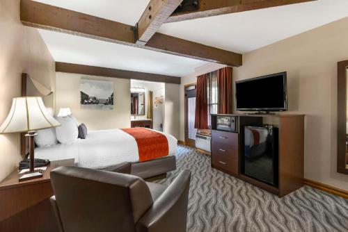 a hotel room with a bed and a flat screen tv at Best Western Plus Rio Grande Inn in Durango