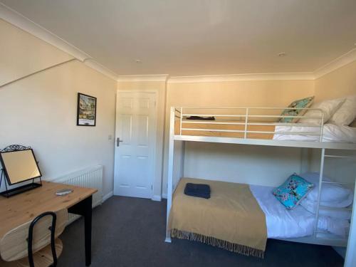 a small room with a bunk bed and a desk at Home in Harrogate in Harrogate