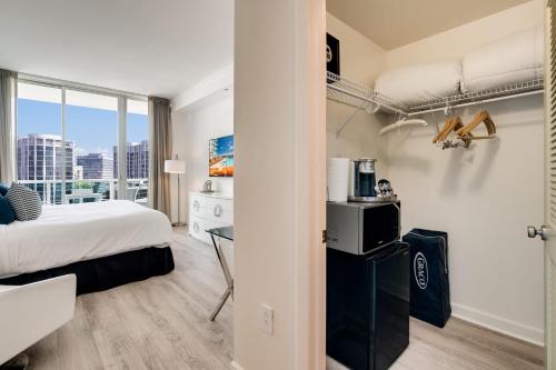 1 dormitorio con 1 cama y escritorio en una habitación en City View Balcony steps from Restaurants, Peacock Park & Marina, en Miami