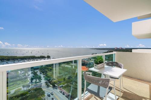 an apartment balcony with a desk and a view of the ocean at Ocean View Balcony steps from Restaurants, Peacock Park & Marina in Miami