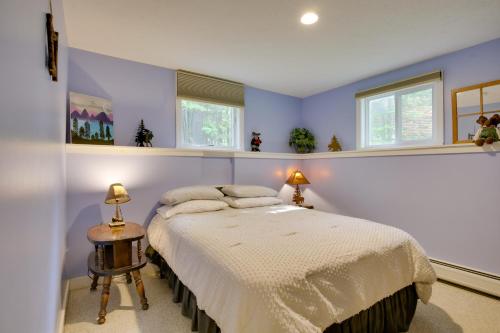 a bedroom with a bed and two windows at Bethel Chalet with Hot Tub 3 Miles to Sunday River! in Bethel