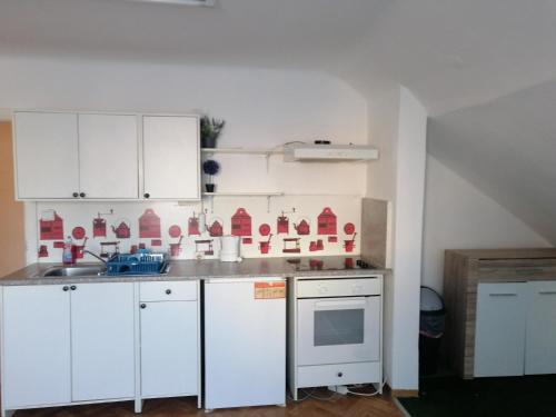eine Küche mit weißen Schränken und einem Waschbecken in der Unterkunft ApartGraz in Graz