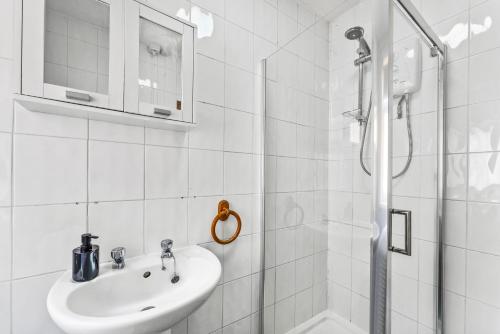 a white bathroom with a sink and a shower at Large Stylish Home - Close to The City - Garden in Spon End