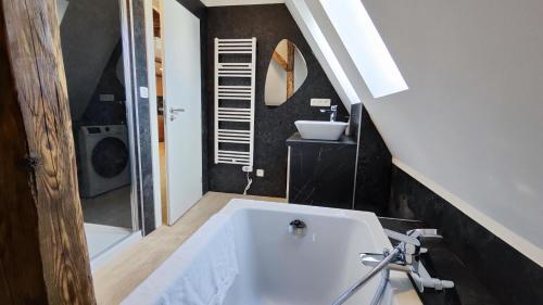 a bathroom with a bath tub and a sink at DOHNANYI Villa by CHORS in Trenčín