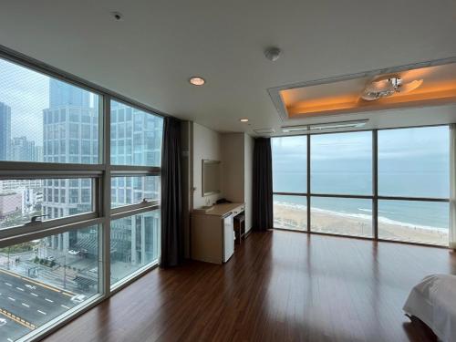 a bedroom with a view of the beach and ocean at Elysia Boutique Hotel in Busan