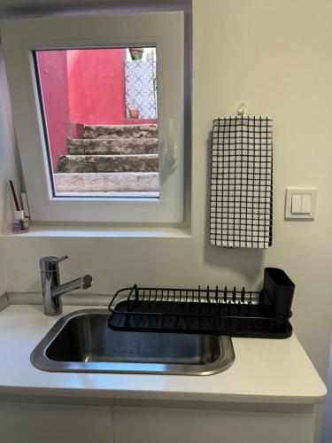 um balcão de cozinha com um lavatório e um espelho em Perfect Studio Mouraria em Lisboa