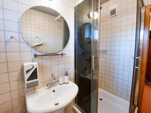 a bathroom with a sink and a mirror and a shower at Morena 203 in Klaipėda
