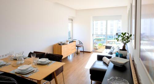 a living room with a table and a couch and a dining room at IH Apartments & Studios in Espinho